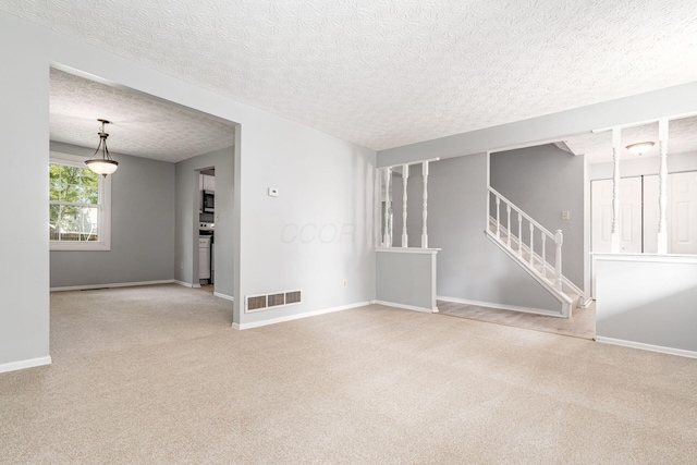 6541 Skywae Dr, Columbus, OH 43229 - spare room featuring carpet flooring, a textured ceiling, baseboards, and stairway
