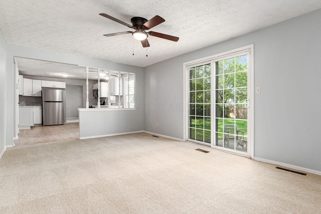 6541 Skywae Dr, Columbus, OH 43229 - unfurnished living room featuring light carpet, ceiling fan, baseboards, a textured ceiling, and a sink