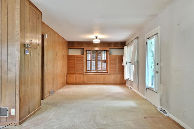 4399 Colerain Ave, Columbus, OH 43214 - unfurnished room with wooden walls, healthy amount of natural light, light colored carpet, and baseboards