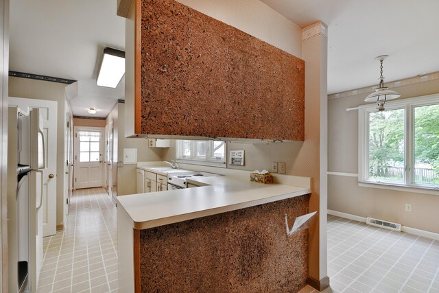 4399 Colerain Ave, Columbus, OH 43214 - kitchen with white appliances, a sink, light countertops, pendant lighting, and a peninsula
