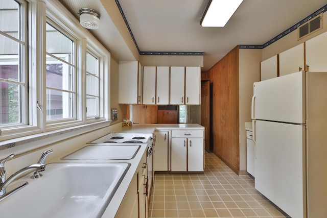 4399 Colerain Ave, Columbus, OH 43214 - kitchen featuring freestanding refrigerator, a sink, light countertops, white cabinets, and light tile patterned floors