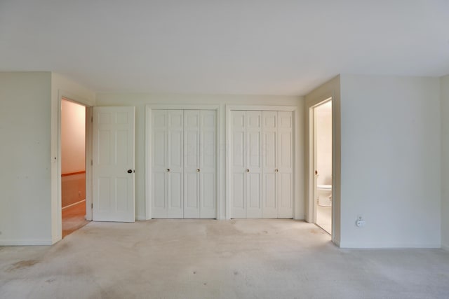 4399 Colerain Ave, Columbus, OH 43214 - unfurnished bedroom featuring multiple closets, carpet, connected bathroom, and baseboards