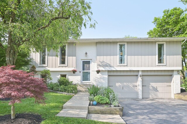 4561 Valley Quail Blvd N, Westerville, OH 43081 - split foyer home featuring a garage, asphalt driveway, and brick siding
