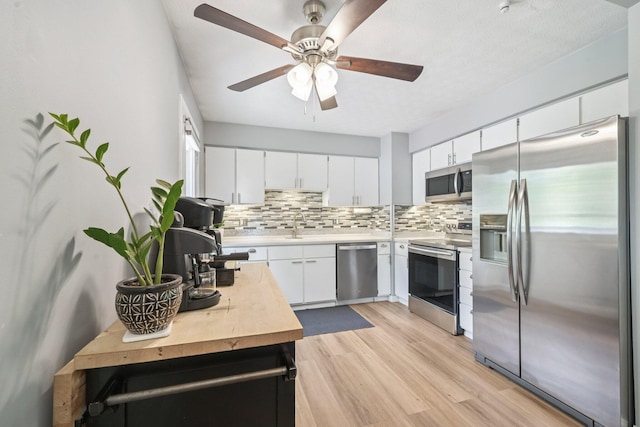 4561 Valley Quail Blvd N, Westerville, OH 43081 - kitchen with stainless steel appliances, decorative backsplash, light wood-style flooring, a ceiling fan, and white cabinets