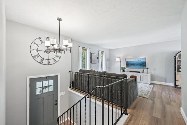 4561 Valley Quail Blvd N, Westerville, OH 43081 - staircase with wood finished floors, a chandelier, baseboards, and a textured ceiling