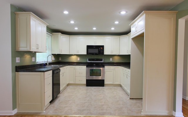 1134 Garden Rd, Columbus, OH 43224 - kitchen with black appliances, a sink, dark countertops, recessed lighting, and baseboards
