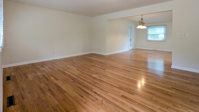 1134 Garden Rd, Columbus, OH 43224 - unfurnished room featuring light wood finished floors, baseboards, and a chandelier