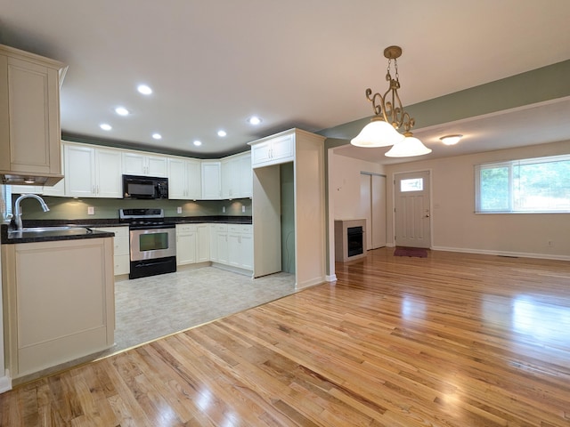 1134 Garden Rd, Columbus, OH 43224 - kitchen with black microwave, stainless steel electric range, a sink, dark countertops, and open floor plan
