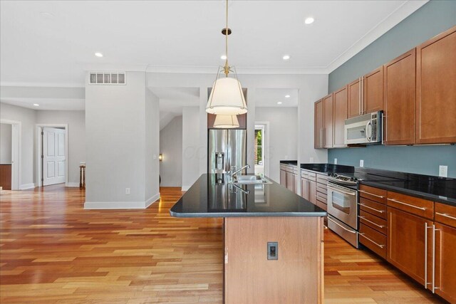 874 S High St, Columbus, OH 43206 - kitchen featuring appliances with stainless steel finishes, a sink, dark countertops, light wood-style floors, and recessed lighting