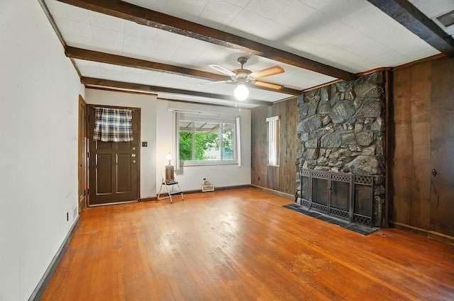 443 Binns Blvd, Columbus, OH 43204 - unfurnished living room featuring wood-type flooring, baseboards, beam ceiling, wooden walls, and ceiling fan