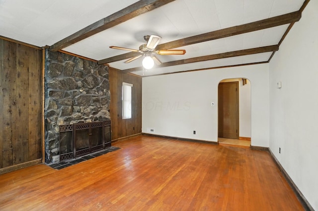 443 Binns Blvd, Columbus, OH 43204 - unfurnished living room featuring arched walkways, wood finished floors, beamed ceiling, baseboards, and ceiling fan