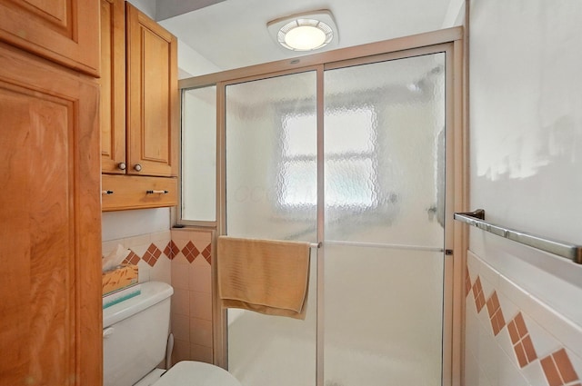 443 Binns Blvd, Columbus, OH 43204 - full bathroom featuring tile walls, toilet, a stall shower, and a wainscoted wall