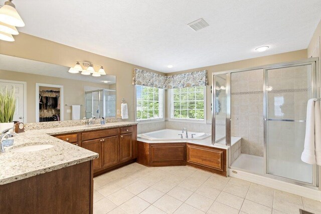 345 Quarter Way, Delaware, OH 43015 - full bathroom with two vanities, tile patterned flooring, a stall shower, a garden tub, and a spacious closet