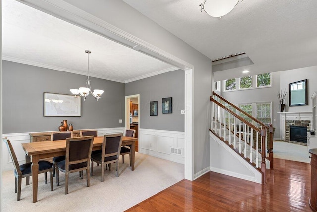 345 Quarter Way, Delaware, OH 43015 - dining room featuring stairway, wood finished floors, a fireplace, a chandelier, and a wainscoted wall