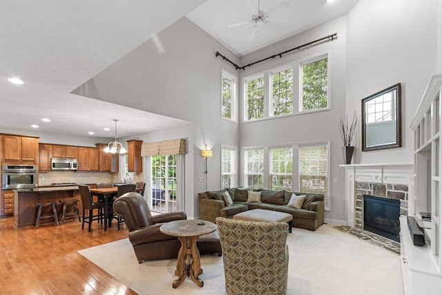 345 Quarter Way, Delaware, OH 43015 - living room featuring a high ceiling, recessed lighting, a stone fireplace, a ceiling fan, and light wood-style floors