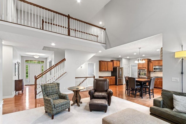 345 Quarter Way, Delaware, OH 43015 - living room featuring light wood finished floors, a high ceiling, recessed lighting, stairway, and a chandelier