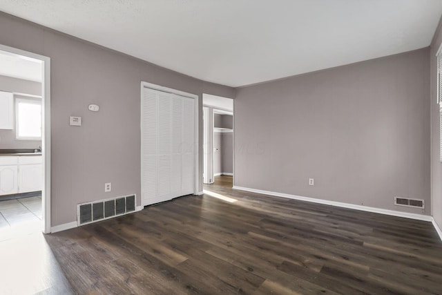 2872 Howey Rd, Columbus, OH 43224 - unfurnished bedroom featuring wood finished floors, baseboards, connected bathroom, a closet, and a sink
