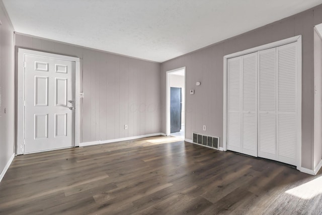 2872 Howey Rd, Columbus, OH 43224 - unfurnished living room with baseboards, dark wood-style floors, and a textured ceiling