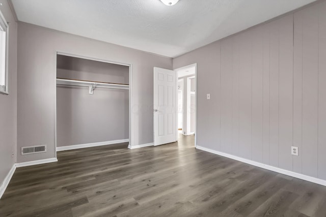 2872 Howey Rd, Columbus, OH 43224 - unfurnished bedroom featuring baseboards, dark wood-style flooring, a closet, and a textured ceiling