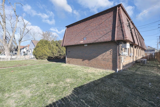 2872 Howey Rd, Columbus, OH 43224 - view of side of property with brick siding, mansard roof, central AC, and roof with shingles