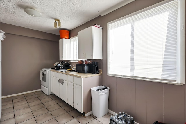 2872 Howey Rd, Columbus, OH 43224 - kitchen with black microwave, plenty of natural light, white cabinets, and a textured ceiling