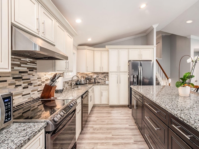 2073 Jeffey Dr, Hilliard, OH 43026 - kitchen featuring appliances with stainless steel finishes, under cabinet range hood, a sink, vaulted ceiling, and ornamental molding