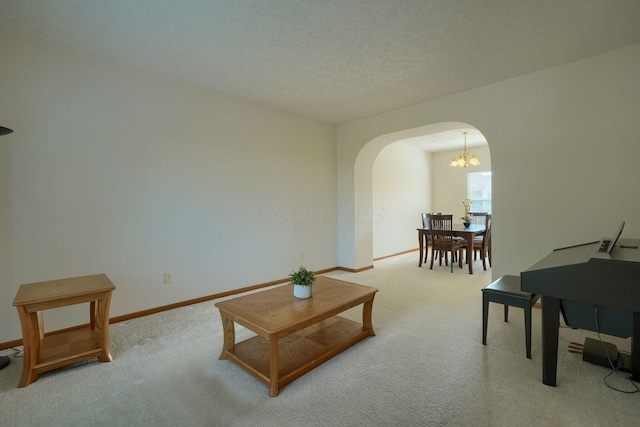 1300 Sotherby Xing, Lewis Center, OH 43035 - living room featuring arched walkways, carpet flooring, baseboards, a chandelier, and a textured ceiling