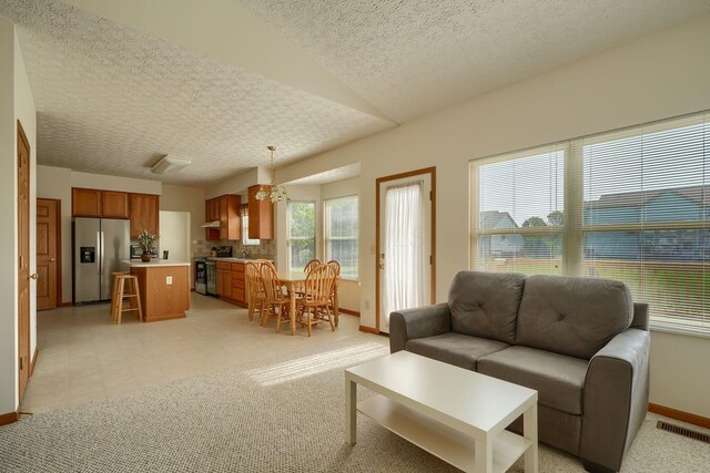 1300 Sotherby Xing, Lewis Center, OH 43035 - living room with baseboards, a textured ceiling, a chandelier, and light flooring