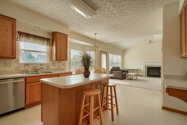 1300 Sotherby Xing, Lewis Center, OH 43035 - kitchen with stainless steel dishwasher, a sink, light floors, open floor plan, and a textured ceiling
