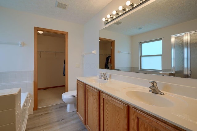 1300 Sotherby Xing, Lewis Center, OH 43035 - bathroom featuring wood finished floors, a stall shower, toilet, double vanity, and a garden tub