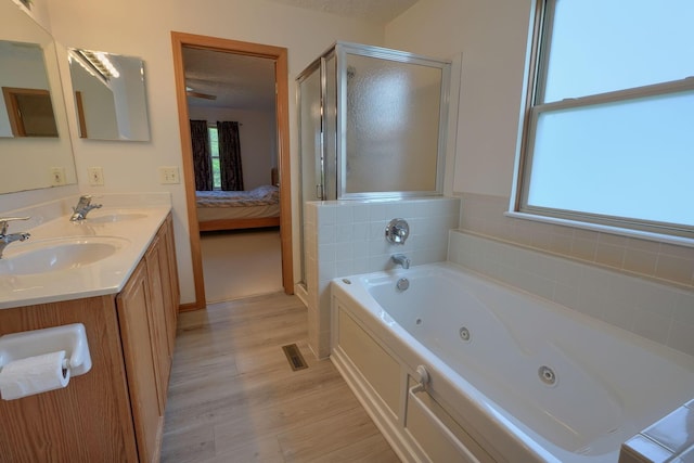 1300 Sotherby Xing, Lewis Center, OH 43035 - bathroom featuring a shower stall, healthy amount of natural light, a whirlpool tub, and wood finished floors