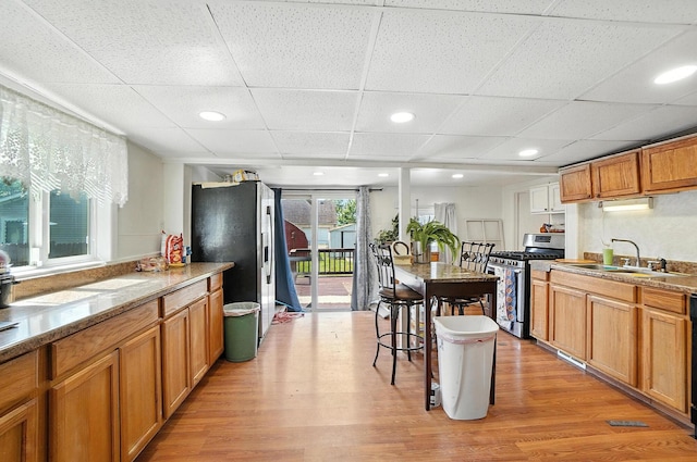 1106 E Walnut St, Lancaster, OH 43130 - kitchen with appliances with stainless steel finishes, light wood-style flooring, brown cabinetry, recessed lighting, and a drop ceiling
