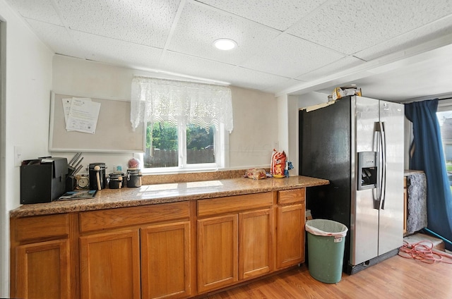 1106 E Walnut St, Lancaster, OH 43130 - kitchen with stainless steel refrigerator with ice dispenser, brown cabinetry, light wood finished floors, a drop ceiling, and light stone counters