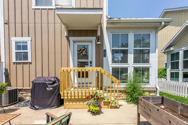 183 W Case St, Powell, OH 43065 - view of exterior entry featuring board and batten siding, cooling unit, and a patio area