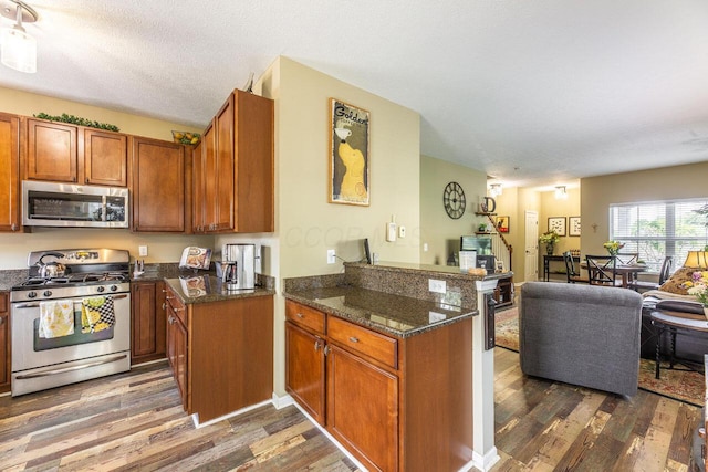 183 W Case St, Powell, OH 43065 - kitchen featuring stainless steel appliances, brown cabinets, wood finished floors, and a peninsula