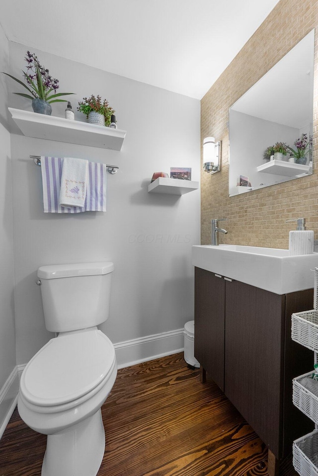 472 Tibet Rd, Columbus, OH 43202 - half bathroom with baseboards, toilet, vanity, and wood finished floors