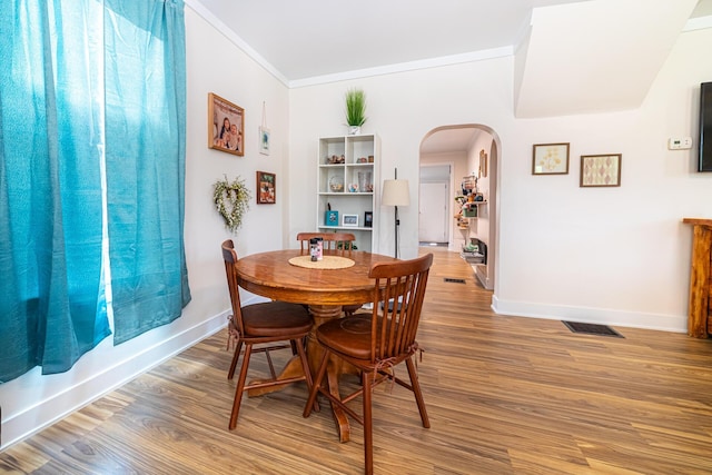77 W High St, Mount Gilead, OH 43338 - dining space with arched walkways, baseboards, crown molding, and light wood-type flooring