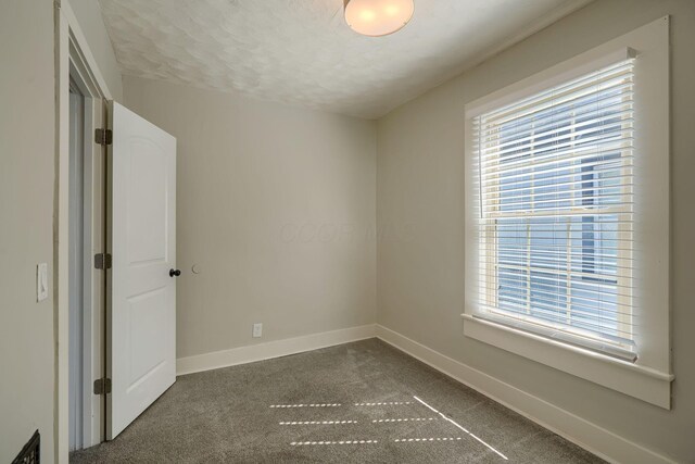 909-915 Wilson Ave, Columbus, OH 43206 - carpeted empty room featuring baseboards, plenty of natural light, and a textured ceiling