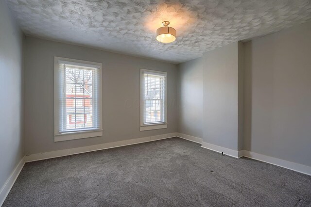 909-915 Wilson Ave, Columbus, OH 43206 - unfurnished room with a textured ceiling, dark carpet, and baseboards