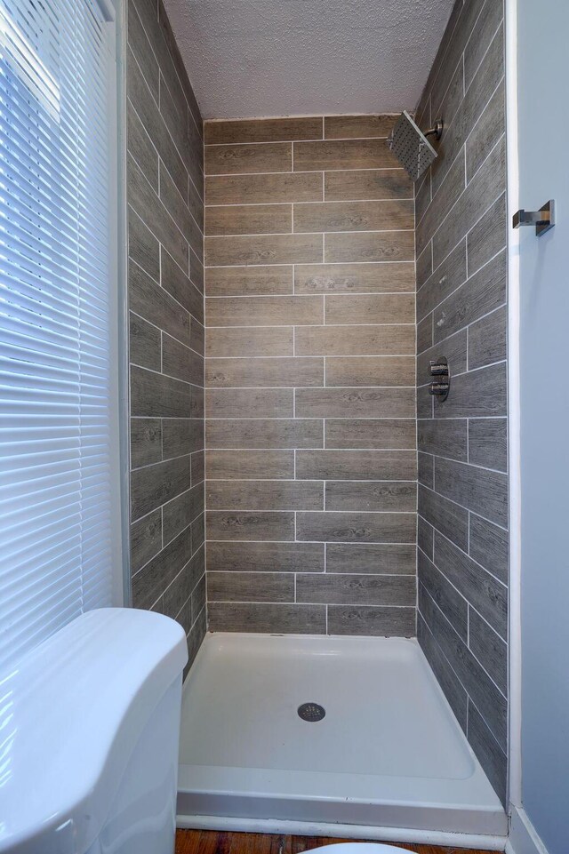 909-915 Wilson Ave, Columbus, OH 43206 - bathroom featuring a tile shower, a textured ceiling, and toilet