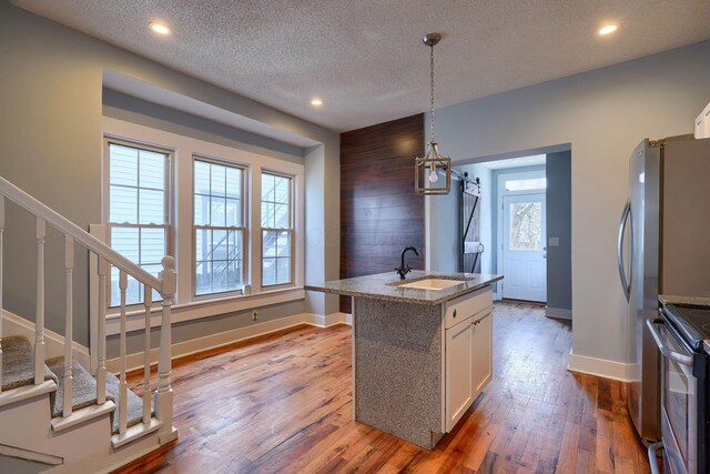 909-915 Wilson Ave, Columbus, OH 43206 - kitchen featuring a sink, electric stove, white cabinets, light wood-style flooring, and baseboards