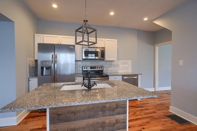 909-915 Wilson Ave, Columbus, OH 43206 - kitchen with stainless steel appliances, baseboards, a sink, wood finished floors, and tasteful backsplash