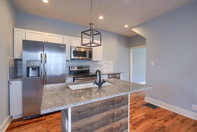 909-915 Wilson Ave, Columbus, OH 43206 - kitchen with appliances with stainless steel finishes, baseboards, a sink, decorative backsplash, and white cabinets