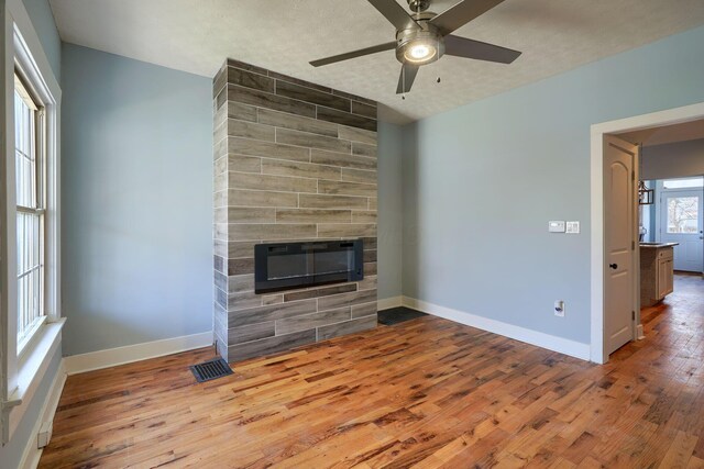 909-915 Wilson Ave, Columbus, OH 43206 - unfurnished living room featuring a large fireplace, wood finished floors, ceiling fan, and baseboards