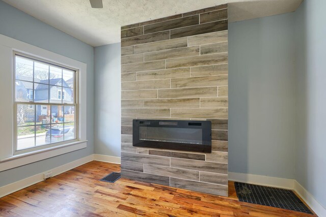 909-915 Wilson Ave, Columbus, OH 43206 - detailed view of baseboards, a tiled fireplace, and wood finished floors