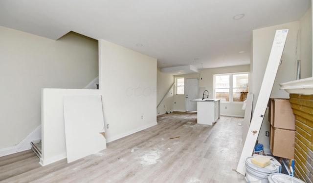1292-1298 E 17th Ave, Columbus, OH 43211 - unfurnished living room featuring a sink, stairway, light wood-style flooring, and baseboards