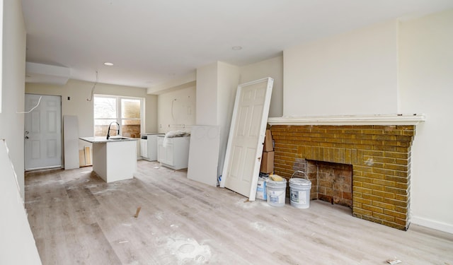 1292-1298 E 17th Ave, Columbus, OH 43211 - unfurnished living room with light wood-style floors, a sink, a brick fireplace, and recessed lighting