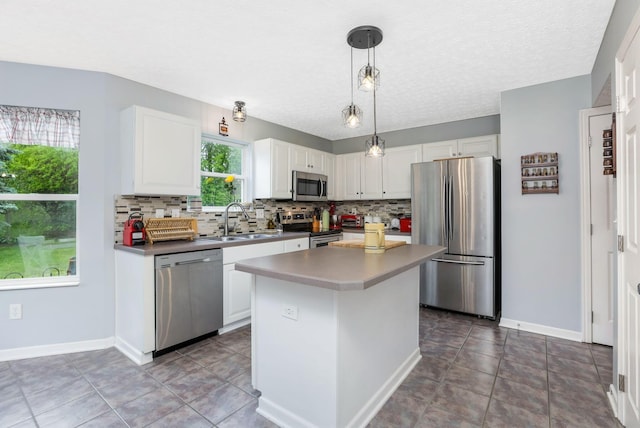 302 Streamwater Ct, Blacklick, OH 43004 - kitchen with appliances with stainless steel finishes, a sink, backsplash, white cabinetry, and a kitchen island