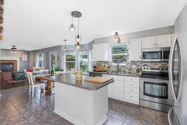 302 Streamwater Ct, Blacklick, OH 43004 - kitchen with appliances with stainless steel finishes, a sink, a textured ceiling, backsplash, and a fireplace