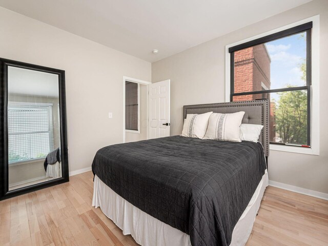 802 N 4th St Unit 802, Columbus, OH 43215 - bedroom with light wood finished floors, baseboards, and multiple windows